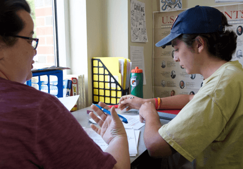 Student getting help with social studies from teacher.
