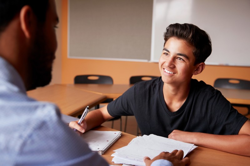 Tutor sitting with a young male student.